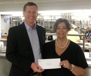 Mark O'Donnell, Executive Director of the Patrick P. Lee Foundation, presents a check to Robyn L. Krueger, Executive Director of Community Missions, to purchase food for the Community Soup Kitchen.